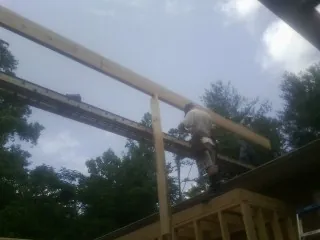 Carpenter setting a ridge beam over a new addition frame — Ice Dam Removal by Roofing Brothers in Fossil