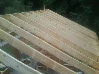 New roof rafters set over an addition before sheathing in Fossil