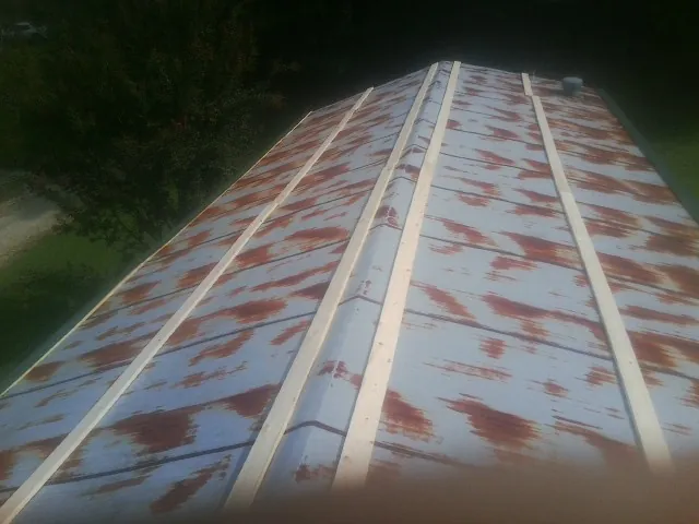 Rusted metal roof panels with new wood purlins before replacement — Storm Damage Roof Repair in Fossil by Roofing Brothers