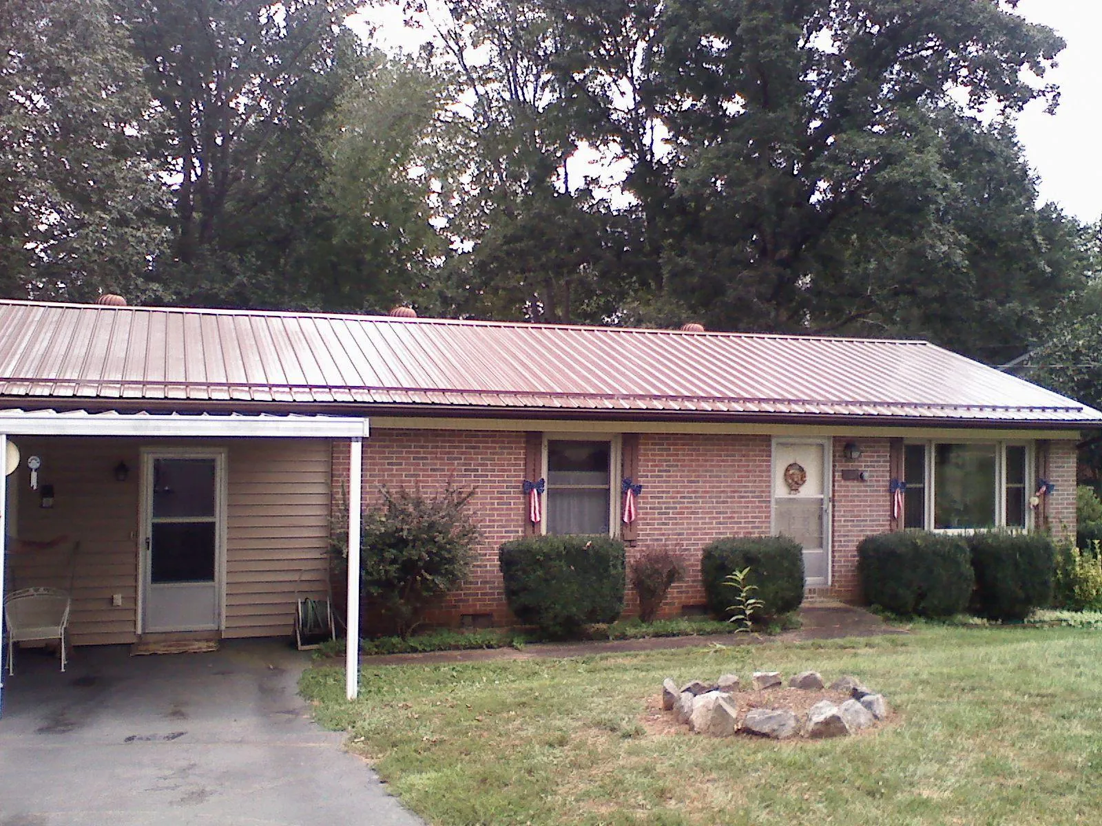 Bronze metal roof and carport on a brick ranch home — Roof Repair work by our crew in Fossil